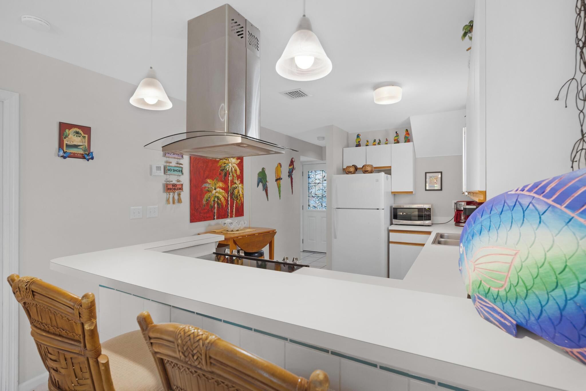 A modern kitchen with white cabinetry, a central island, and pendant lighting.