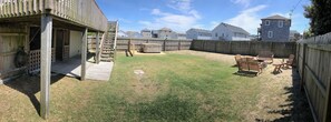Ein Garten mit einer Holzterrasse, einem Whirlpool und Gartenmöbeln.