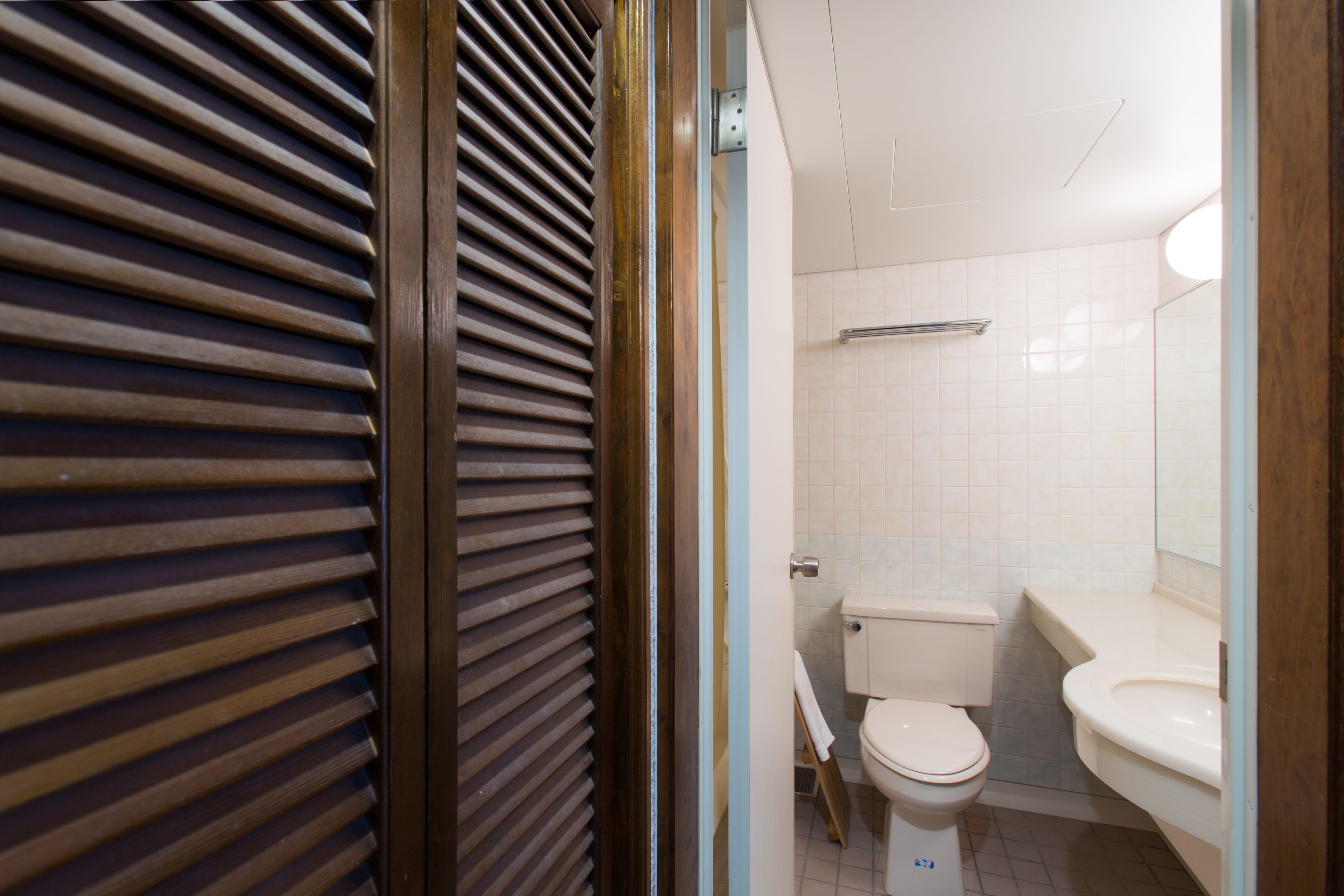Une salle de bain avec des toilettes, un lavabo et un miroir.