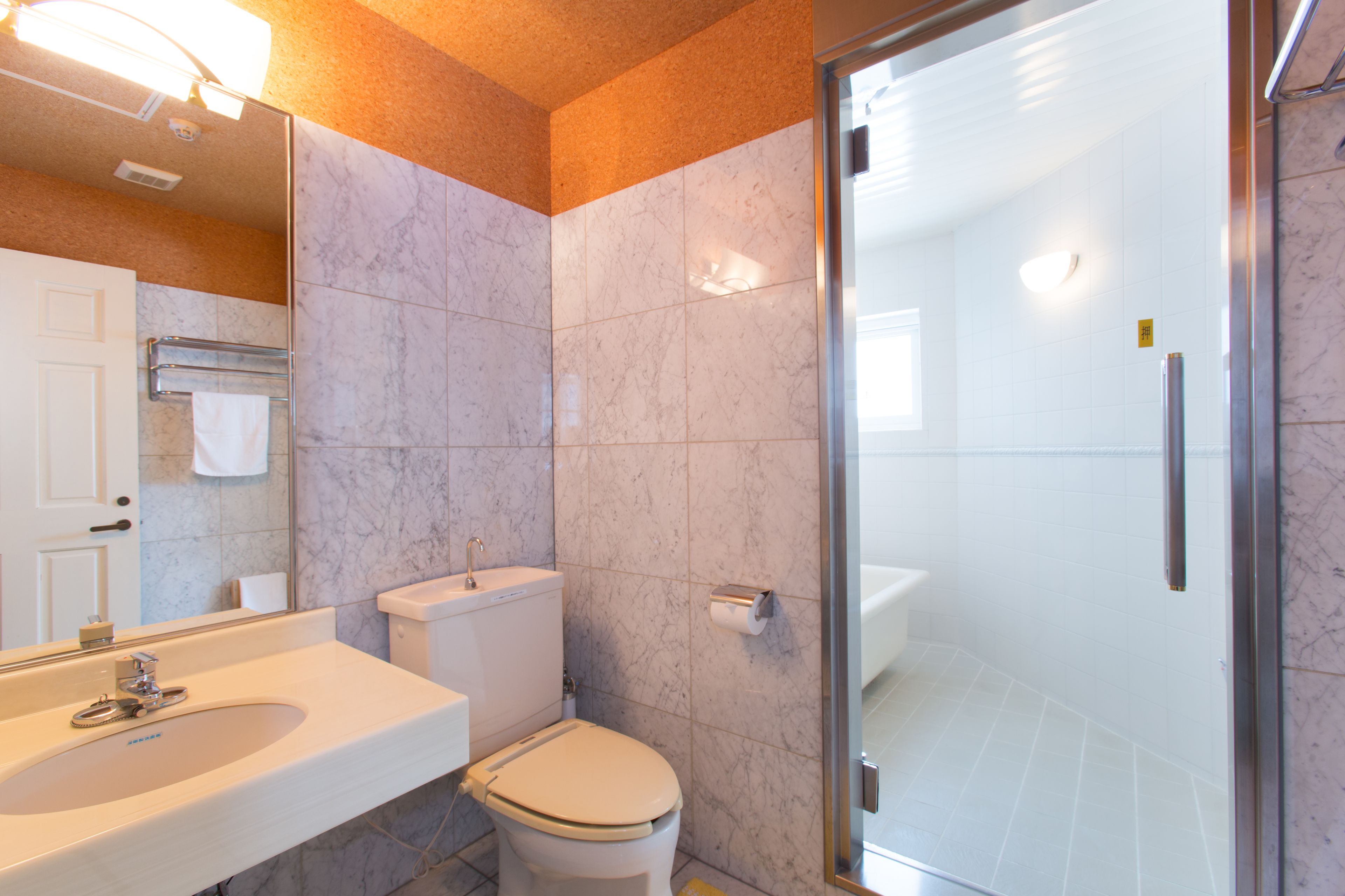 A modern bathroom with a sink, toilet, and glass shower enclosure.