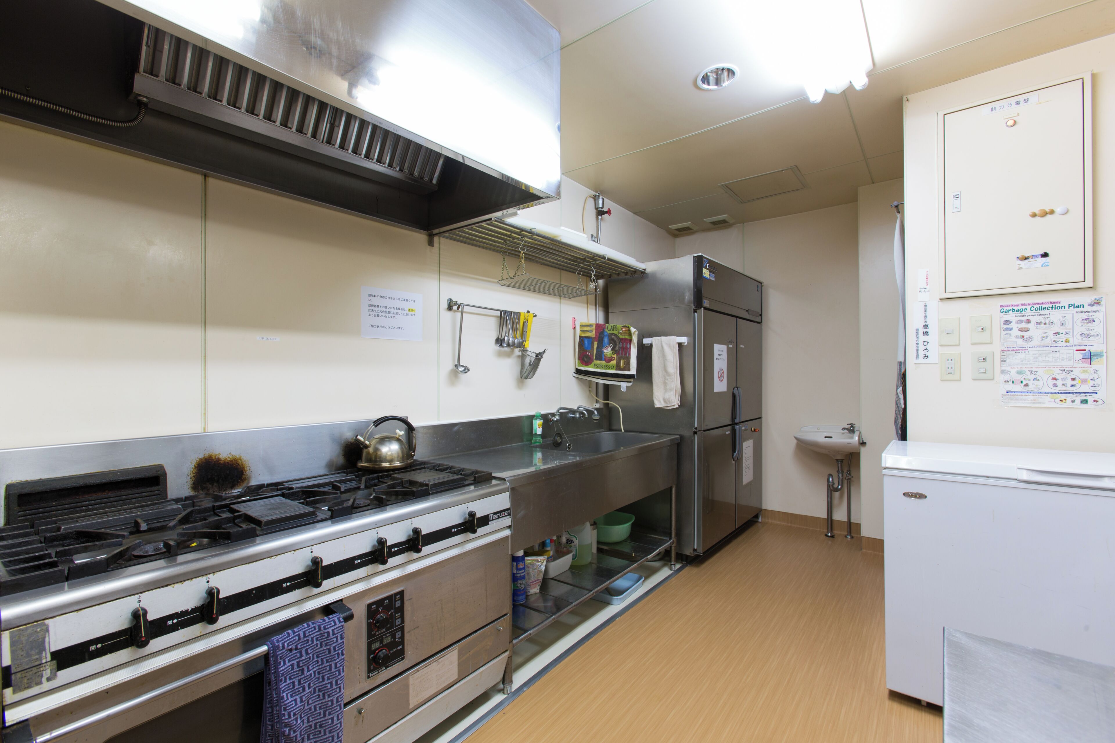 A kitchen with stainless steel appliances, a gas stove, a sink, and a refrigerator.
