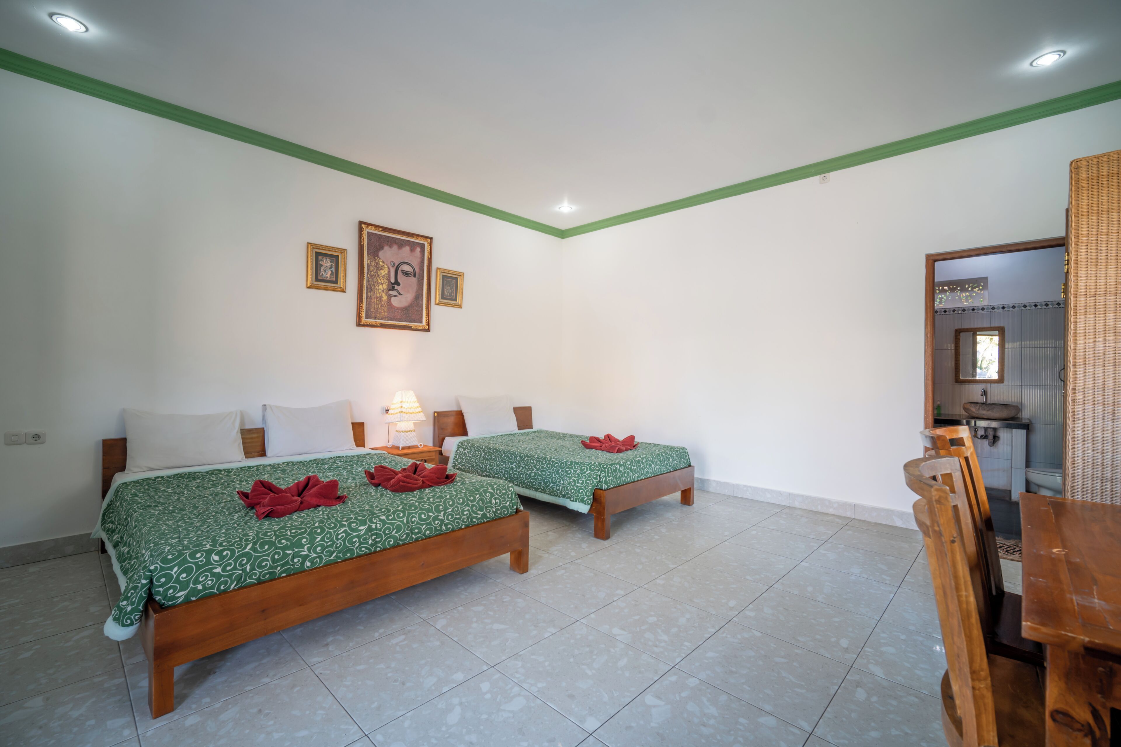 A room with two wooden beds, a dining table, and a small kitchenette.