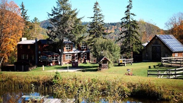 A rustic cabin with a large barn, surrounded by a pond and dense forest. - Chester Farmhouse on 100 Acres, 15 Min to Okemo! (Chester)