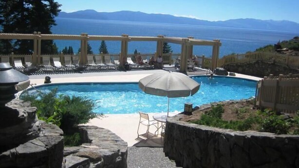 Ein Poolbereich mit Blick auf das Meer und die Berge.