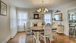 A dining room with a wooden table, white chairs, and a chandelier. - Central Wadesboro Home: Walk to Downtown Shops! (Wadesboro)