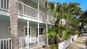 Een tweelaags huis met een balkon, een voordeur en een brievenbus.