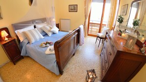 Quarto com cama, mesa de cabeceira, luminária e bandeja com itens de café da manhã.