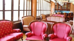Una habitación con un ventanal grande, una mesa redonda de cristal y varias sillas tapizadas.