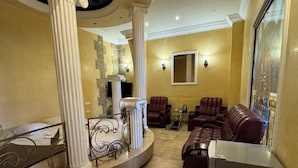 A spacious living area with a curved column structure, leather sofas, and a marble floor. - Bella Hotel (Yerevan)