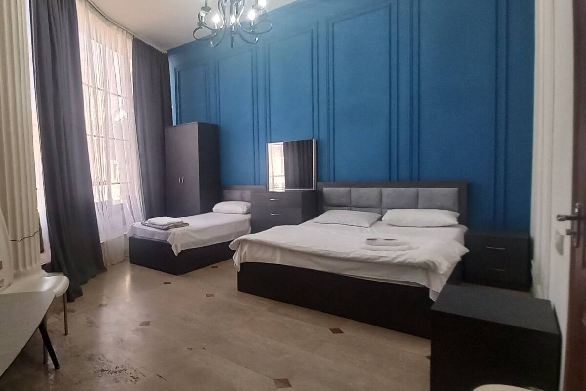 Ein Schlafzimmer mit zwei Betten, einem Schminktisch, einem Spiegel und einem Schreibtisch.