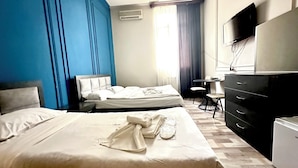 A hotel room with two beds, a desk, a chair, a TV, and a dresser. - Bella Hotel (Yerevan)
