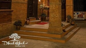 Edifici tradicional amb un gran pilar central, diverses finestres i entrada ben il·luminada.