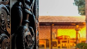 Edifici tradicional amb teulada arajolada i taula i cadires de fusta al primer pla.
