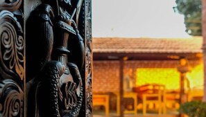 Edifici tradicional amb teulada arajolada i taula i cadires de fusta al primer pla.