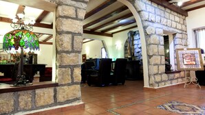 A stone-walled interior with a chandelier, a fireplace, and a dining area. - Beit Shalom Historical Boutique Hotel (Metula)