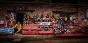 A souvenir shop with various items displayed outside, including masks, jewelry, and textiles. - Hotel Marinha (Kathmandu)