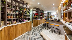 A modern interior with wooden and metal shelves displaying various items, a herringbone-patterned floor, and a bar area with stools. - Sun Moon Tea Hotel (Yuchi)