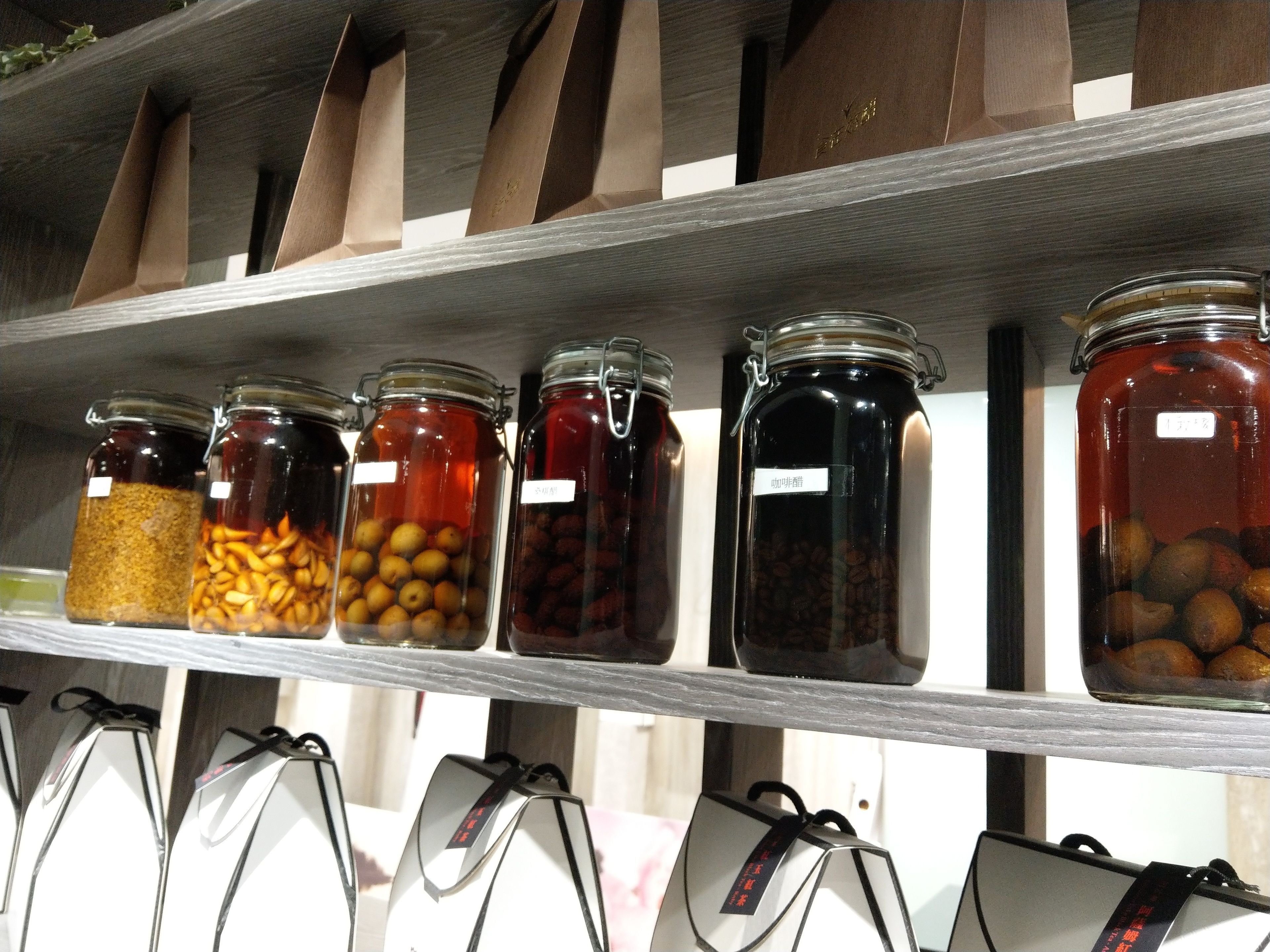 A shelf with various jars containing different food items.