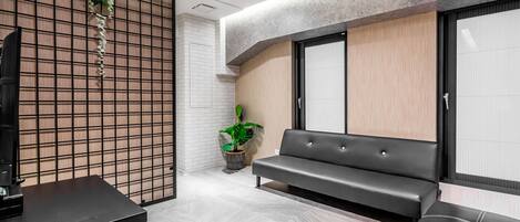 A modern waiting area with a sofa, a table, and a potted plant.