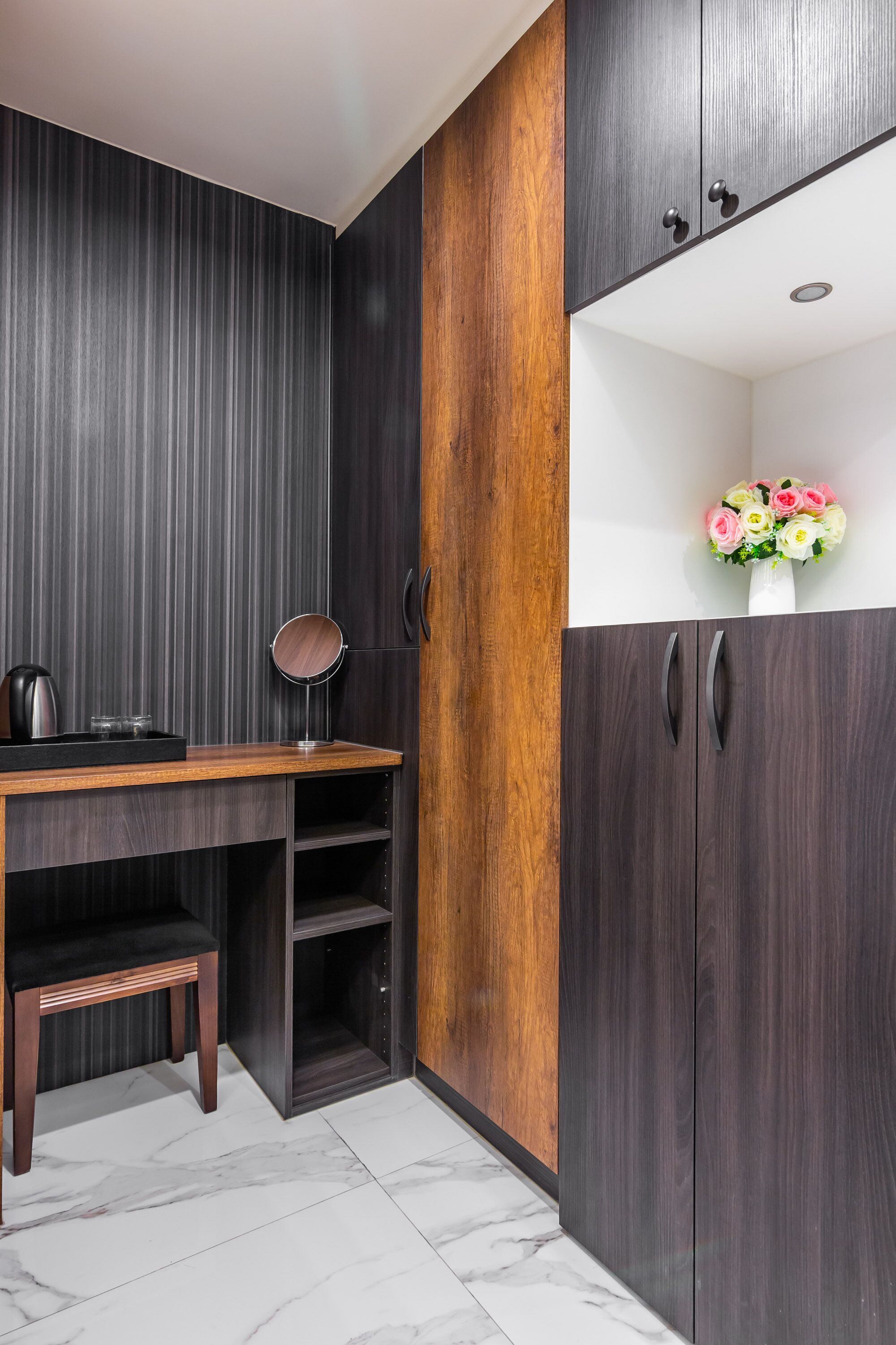 A modern kitchen with dark wood cabinets, a wooden countertop, and a marble floor.