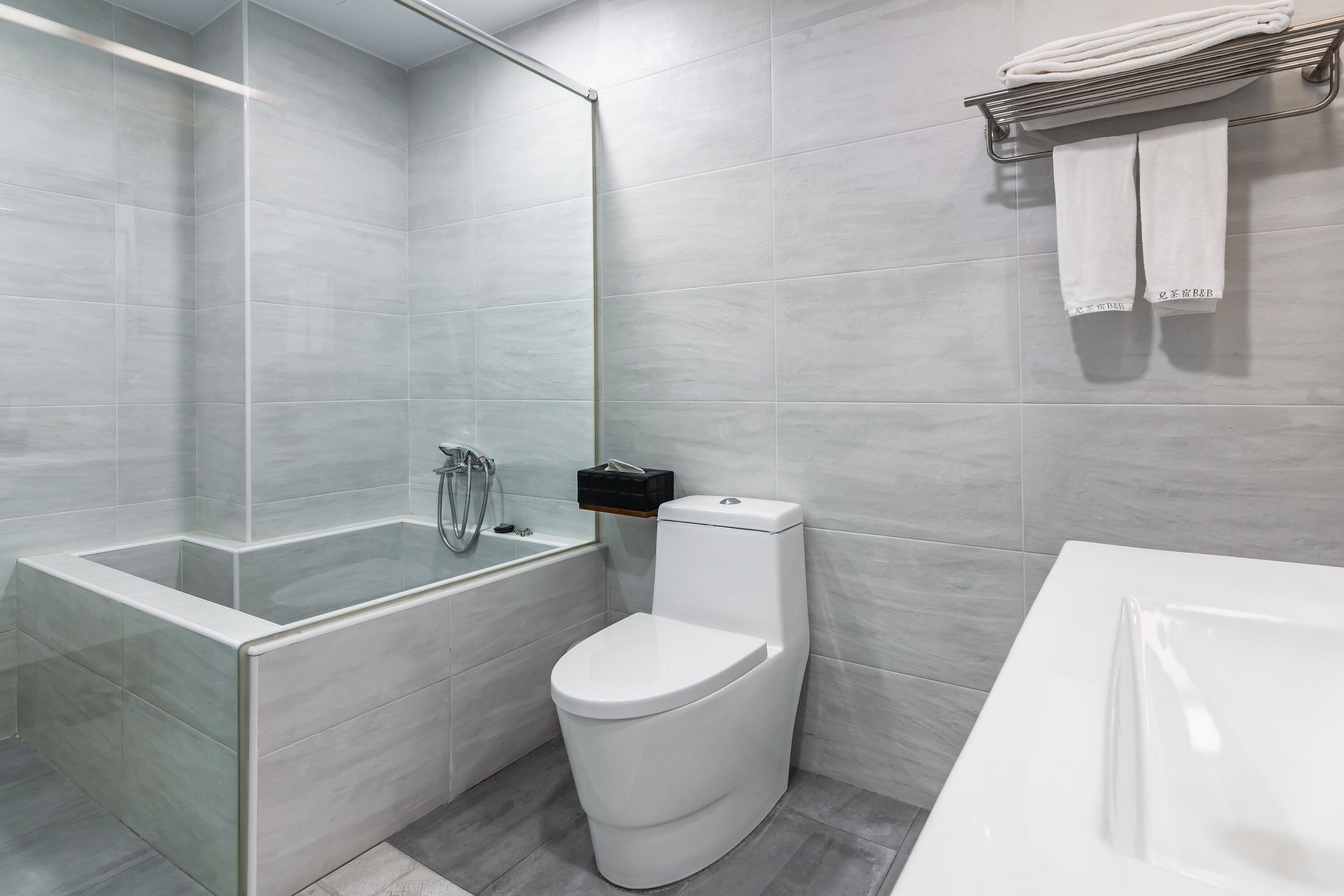 Un baño moderno con ducha de vidrio, inodoro blanco y bañera.