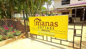 Placa amarela para Manas Cottage, indicando que é um local de acomodação com quartos nas categorias prata e ouro.