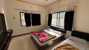 Une chambre d’hôtel avec un lit, une table de chevet, une fenêtre avec des rideaux et une vue sur l’extérieur.