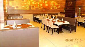 Interno di un ristorante con banconi e tavoli apparecchiati, caratterizzato da un design moderno con motivi geometrici sulle pareti e illuminazione a incasso.