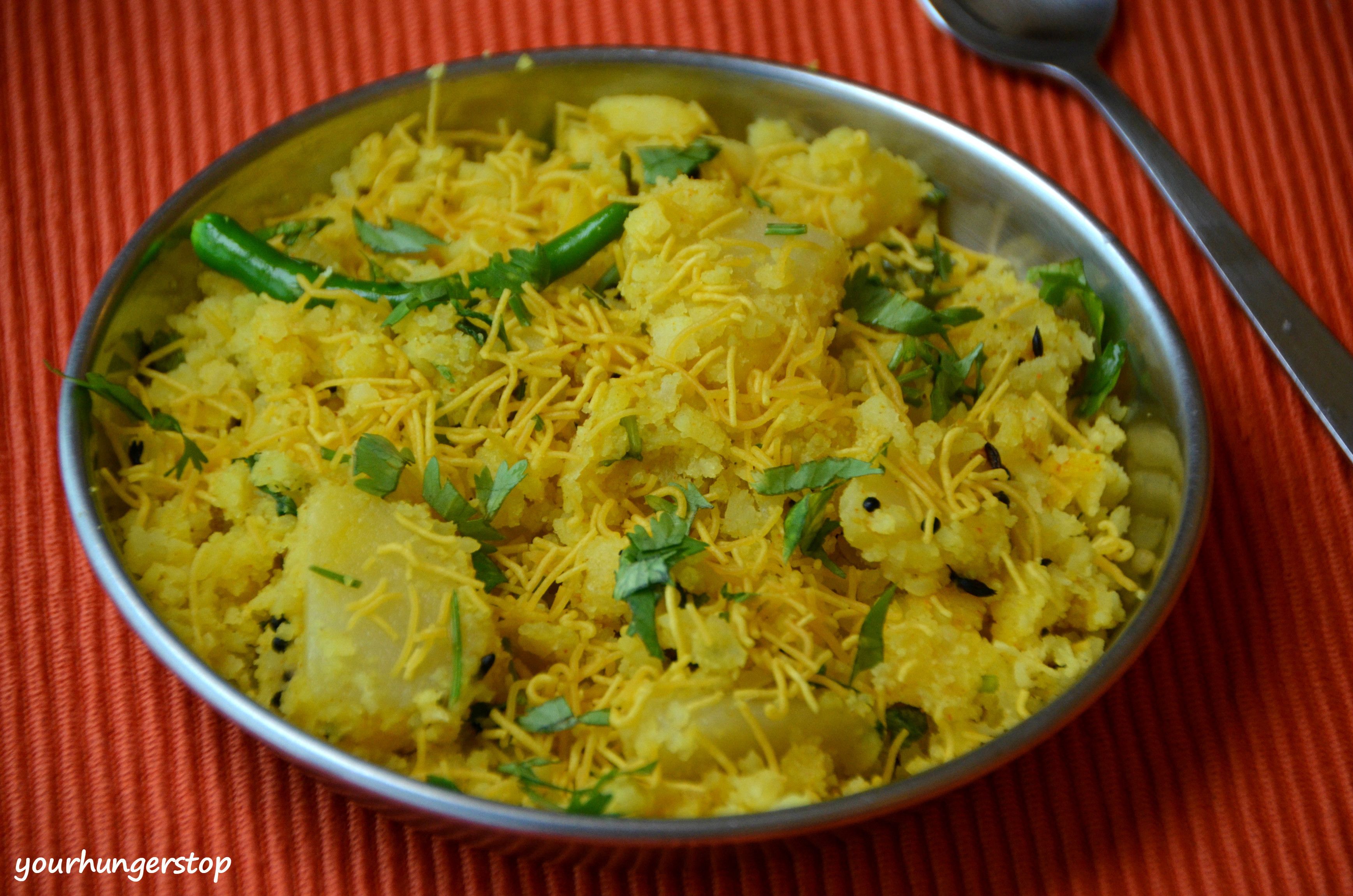 A bowl of yellow rice with green beans and shredded cheese on a red cloth.