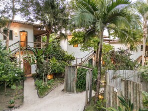 A rustic house with a dirt path leading to a wooden staircase. - Hotel Boutique Bahia Bonita (Porto Seguro)