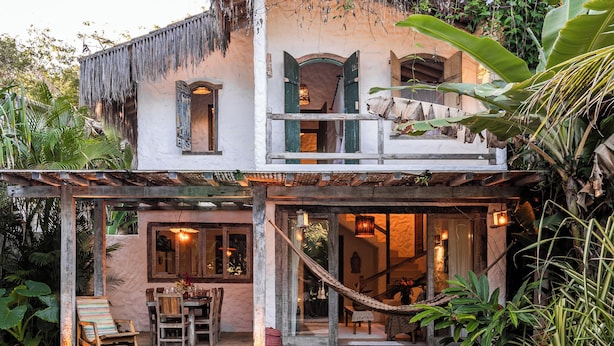 A house with a pool, a covered patio, and lush greenery. - Hotel Boutique Bahia Bonita (Porto Seguro)