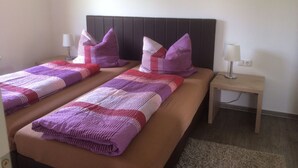 A double bed with a headboard, two nightstands, and a wall-mounted lamp.