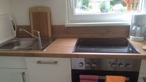 A kitchen with a sink, stove, and oven.