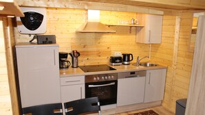 A compact kitchen with a stove, oven, sink, and a small countertop. - Cozy vacation home in beach location for 4 people and only 100m to the bathing area (Plau am See)