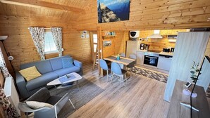 A cozy cabin interior with a living area, dining space, and kitchen. - Cozy vacation home in beach location for 4 people and only 100m to the bathing area (Plau am See)