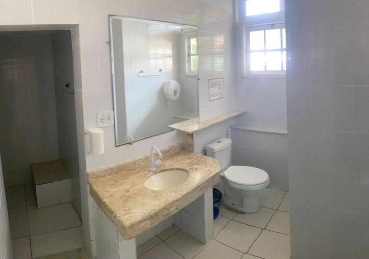 A bathroom with a marble sink, a toilet, and a mirror.