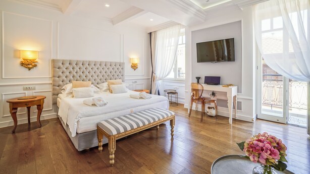 Une chambre spacieuse avec un grand lit, des tables de chevet, un bureau et un téléviseur.