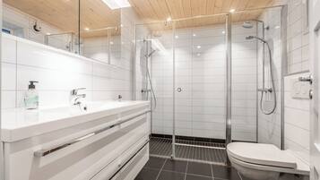 A modern bathroom with a glass-enclosed shower, white tiles, and a wooden ceiling.