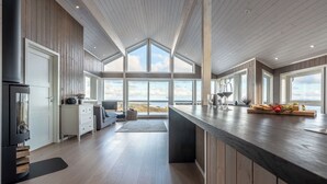 Una cocina espaciosa con ventanas amplias, techo de madera y vistas al exterior.