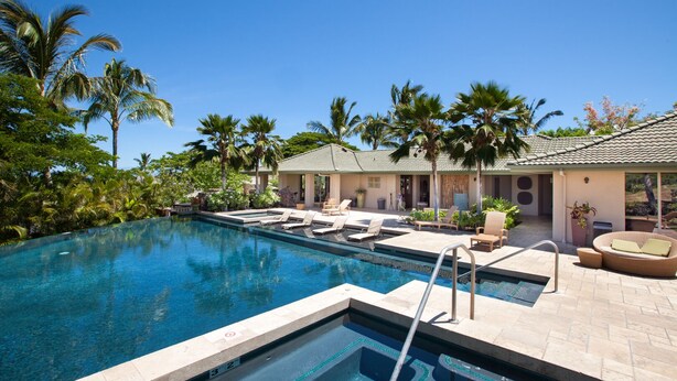 A pool area with lounge chairs and a building with a tiled roof. - Oceanview Mauna Kea Luxury Villa - Private Pool & Spa - In-home Chefs Available (Waimea)