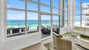 A spacious living room with large windows, a sofa, and a coffee table.