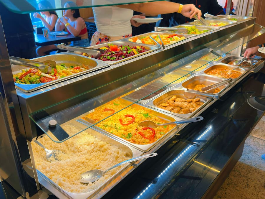 Un bufé con diversas opciones de comida, como arroz, verduras y carnes.