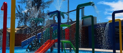 A swimming pool with water features and slides.