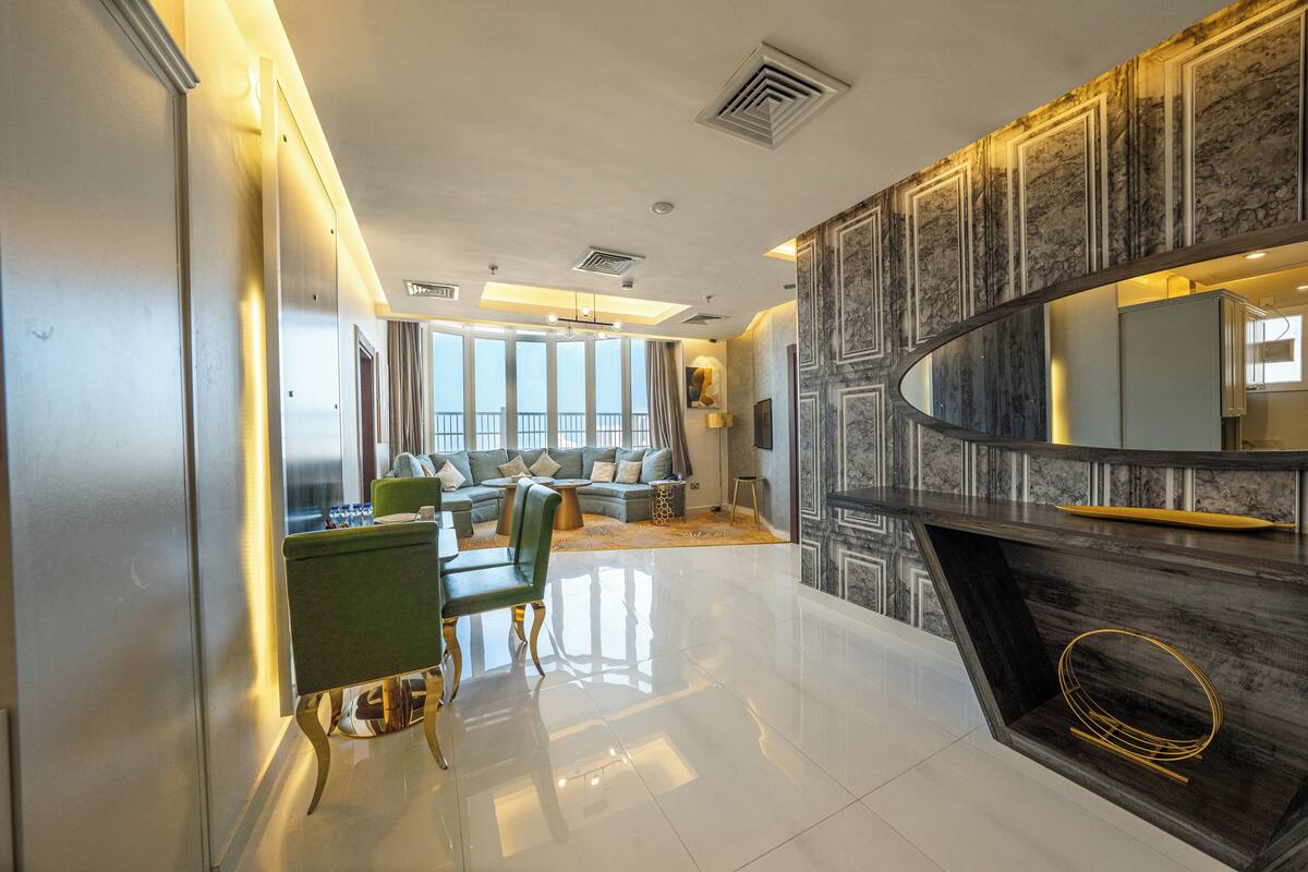 Una sala de estar moderna con chimenea, un conjunto de sofás y una zona de comedor.