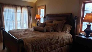 Una camera da letto con un letto grande, due lampade da comodino e una finestra con tende.
