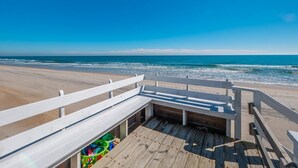 A wooden deck with a white railing overlooking a beach. - The Shark and the Seahorse | Ocean Views + Pet-Friendly (Surf City)