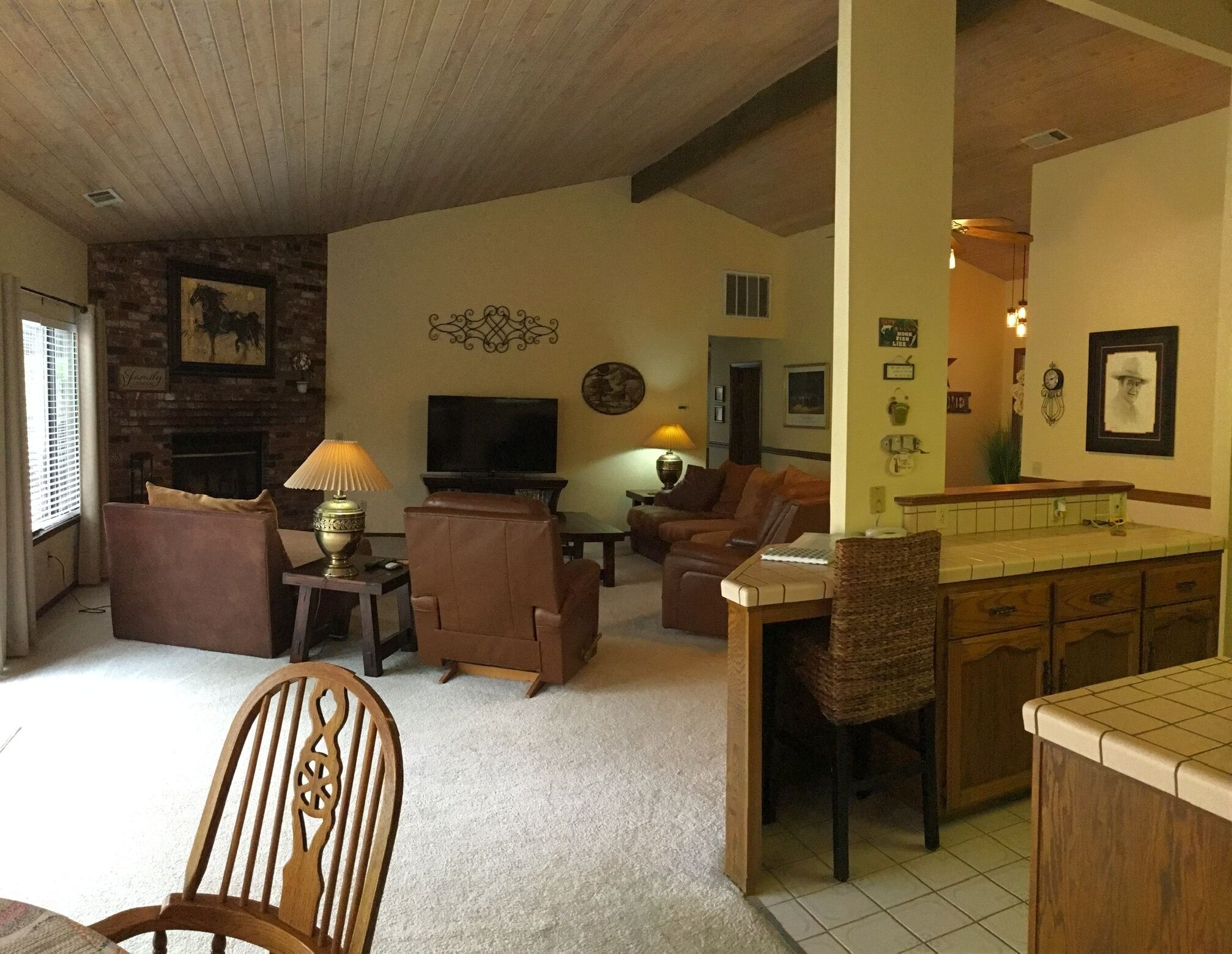 Un soggiorno con camino, televisione e zona pranzo con isola della cucina.