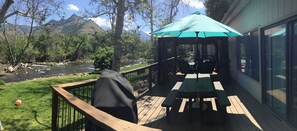 A deck with picnic tables and a covered seating area overlooking a river and mountains. - "Peaceful Riverfront #1" only 6 miles to park entrance  (Three Rivers)
