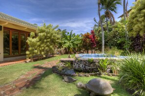 A tropical garden with a swimming pool, a stone pathway, and a large tortoise on the grass. - Beautiful Views, Walk To Beaches And Restaurants (Koloa)
