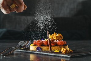 A dessert with raspberries, nuts, and a chocolate stick on a plate. - Novotel Brisbane South Bank Hotel (South Brisbane)